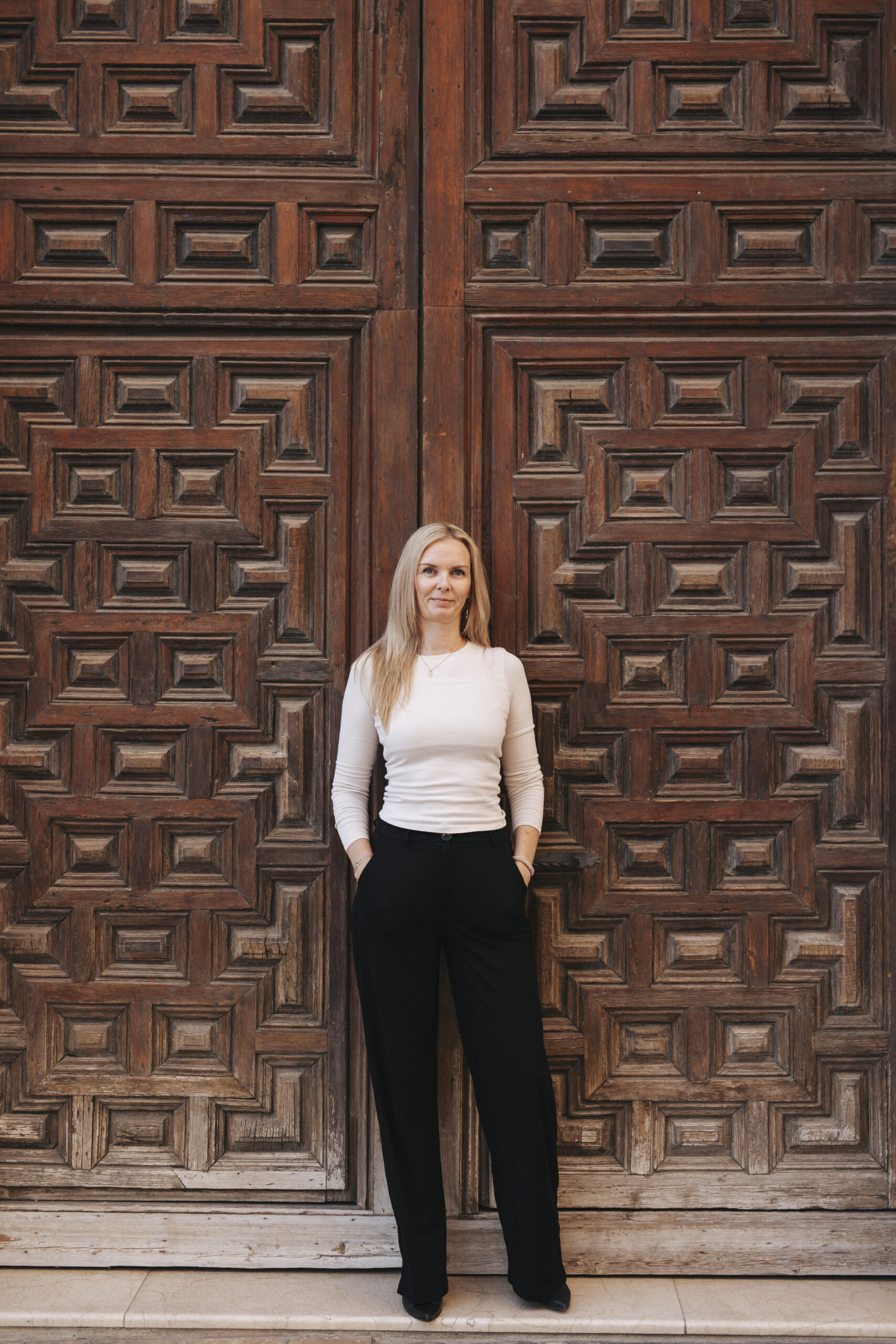 Mirjam Kooijman, virtual assistant bij Get Your VA, in professionele outfit voor een houten deur